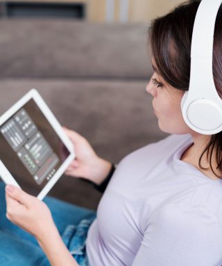 young-woman-in-headphones-looking-at-remote-4ZG96T5.jpg